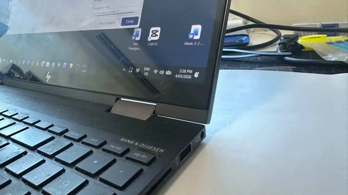 A high-end laptop with a perfectly repaired hinge sitting on a workshop bench
