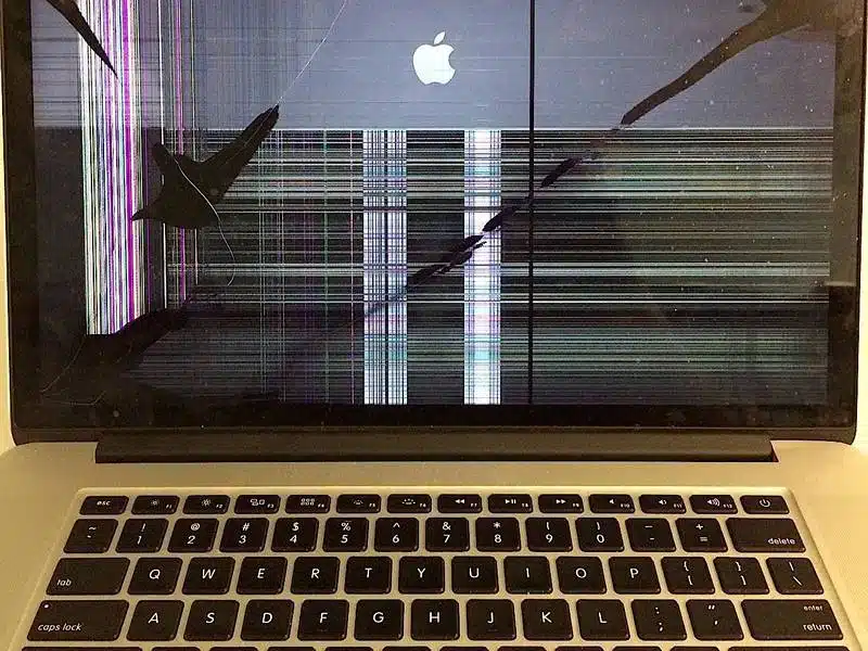 Close-up of a severely cracked MacBook Pro screen before replacement at the Fix My Laptop workshop in Brisbane.